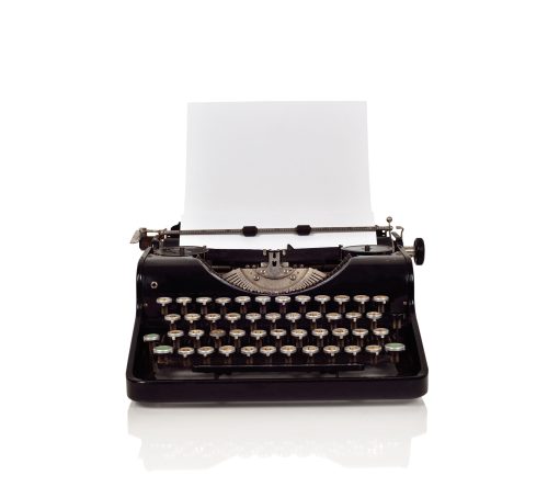 Vintage typewriter with paper on a white background